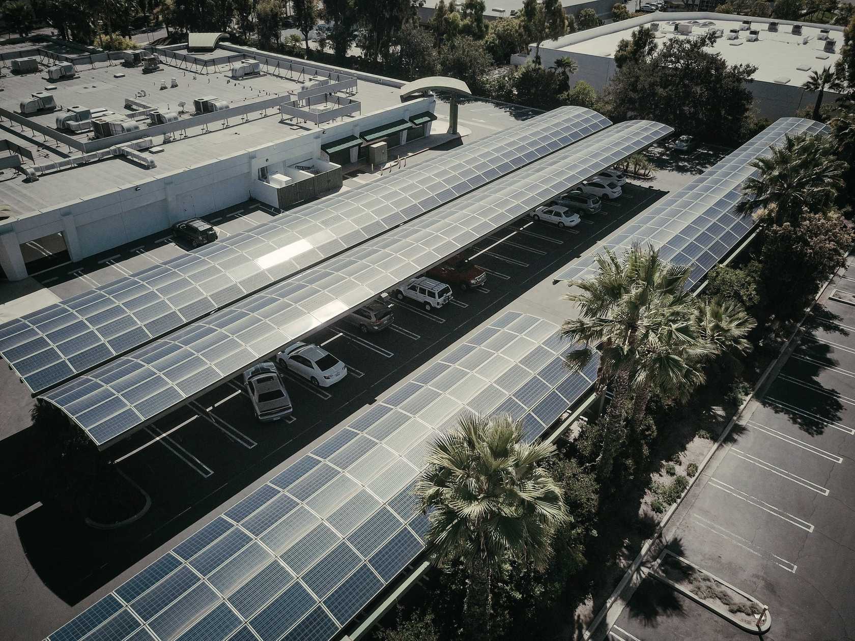 Vue aérienne d'un parking couvert de rangées d'ombrières photovoltaïques